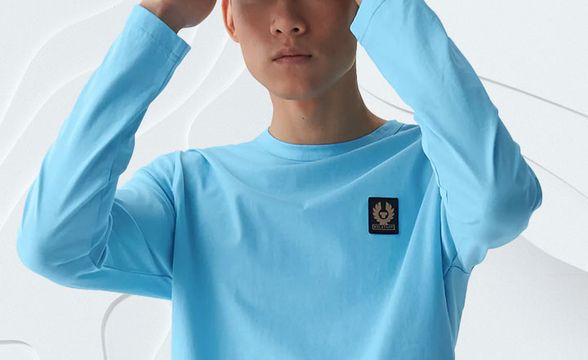 Male Model wearing the Belstaff Long Sleeve T-Shirt in Horizon Blue and Phoenix Logo Cap in Horizon Blue.